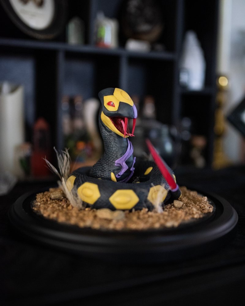 Seviper Pokemon Terrarium
Seviper coils through a small handmade terrarium in Overcast Oddities' Pokémon line. A snake in a display case is either a collection or an extremely polite warning. 🐍